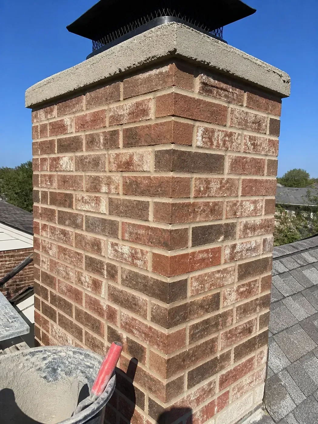 Brick repair Dallas: Professional chimney repointing showing clean mortar joints on a Texas home.