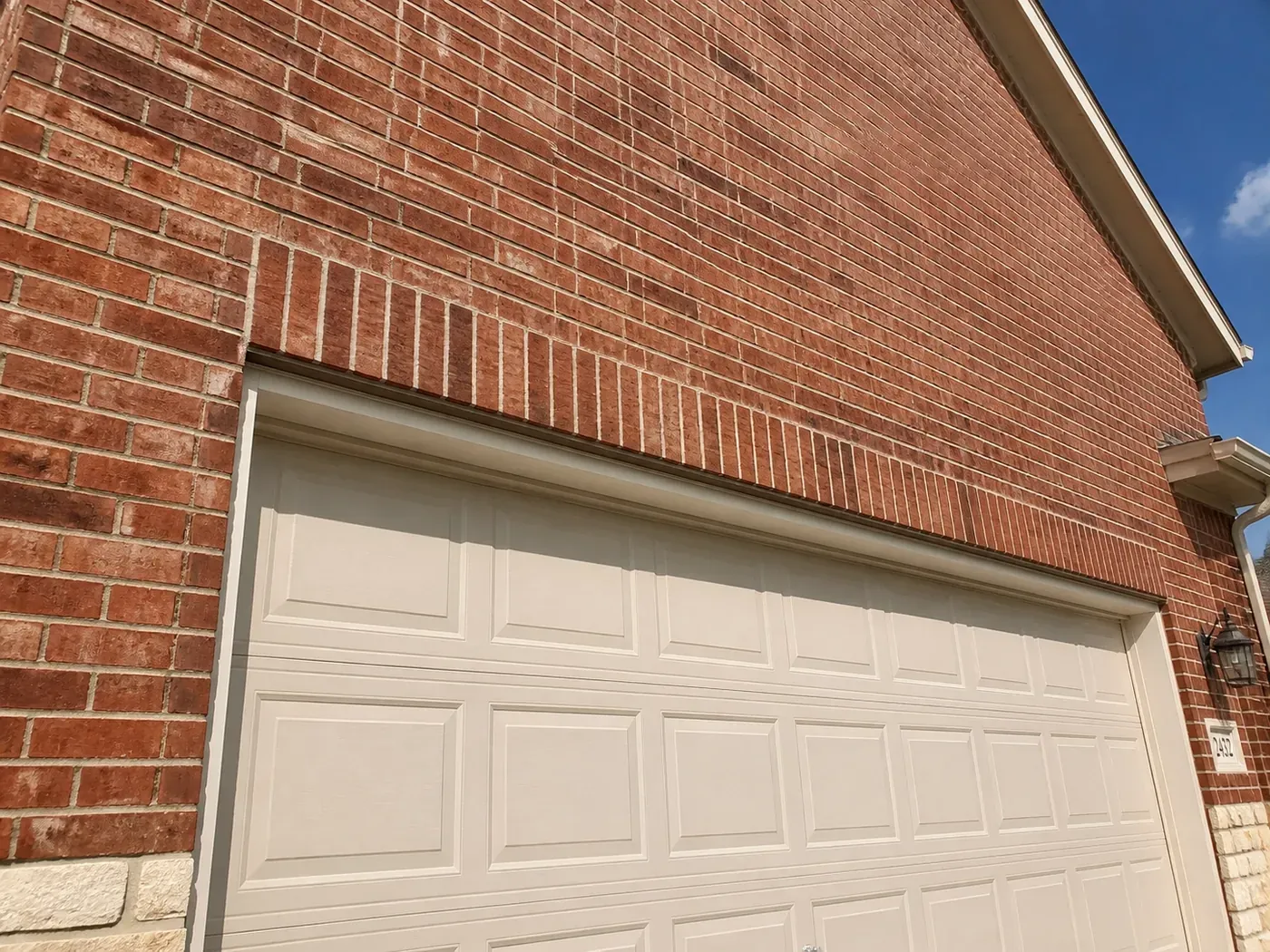Completed Dallas brick repair above a garage door illustrating a permanent, engineered masonry solution.