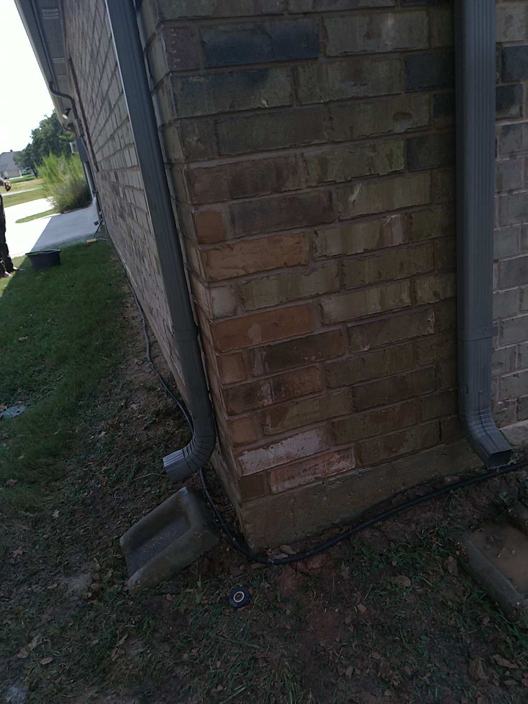 Brick wall corner showing visible mortar discoloration and previous repair signs indicative of movement