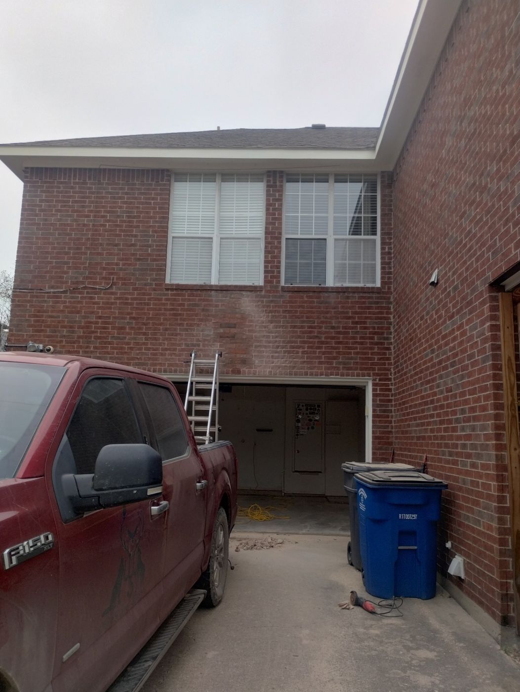 Garage lintel repair in progress above a two-car garage door